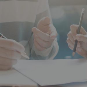 Close up photo of two persons signing documents 1