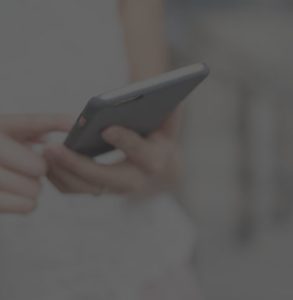 A woman standing and texting on her smartphone