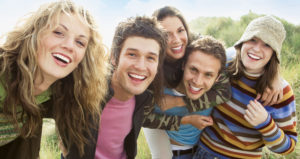 Group of teenagers hugging and smiling together, showing friendship and happiness