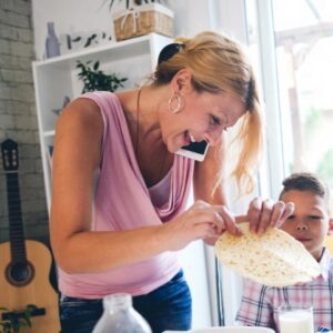 woman at home with child while talking on the phone