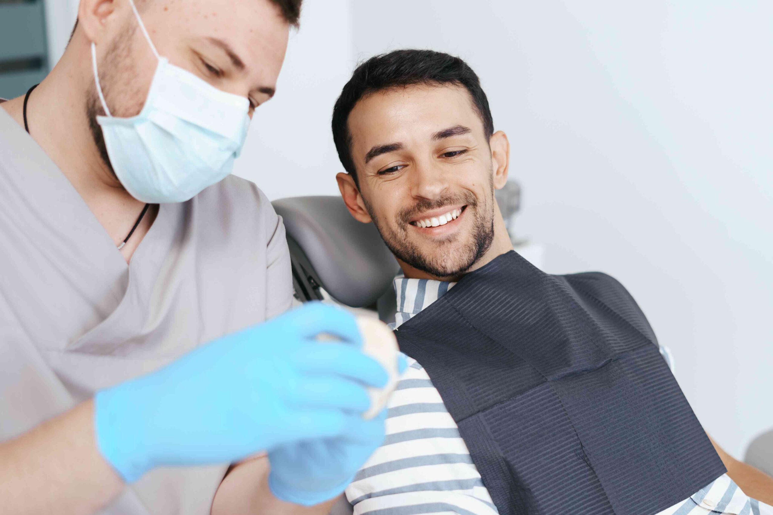 Dentist discussing treatment with a smiling patient.